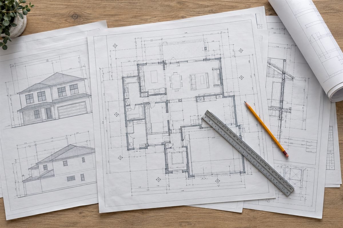 Overhead view of a residential construction drawing set with floor plans, elevations, a scale ruler and pencil, of the kind submitted to the City of San Diego for plan check